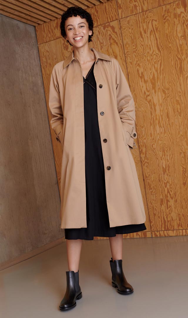 Woman wearing beige coat and black boots